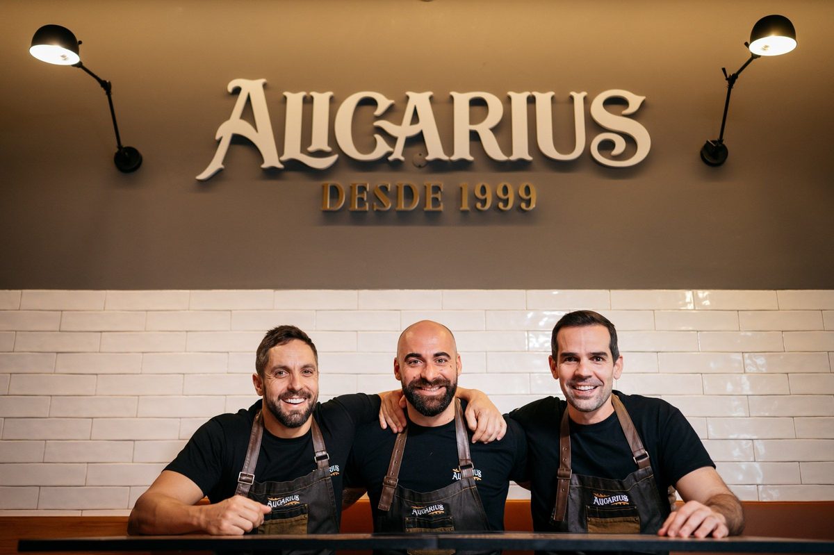 Os três sócios do Alicarius debaixo do letreiro Alicarius desde 1999